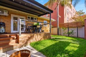 a backyard with a wooden deck with a table and chairs at Oak and Olive - Glenelg in Glenelg