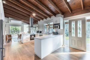 a kitchen with a white island in a room at Gangurru in Myrtleford