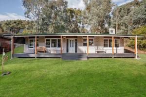 a house with a green lawn in front of it at Gangurru in Myrtleford