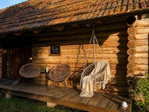 a log cabin with two chairs and a table at Sepasauna holiday house in Joaveski +16 photos