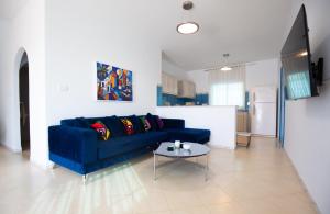 a living room with a blue couch and a table at Villa Aura in Ouled Yaneg