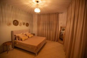 a bedroom with a bed and a chandelier at Villa Aura in Ouled Yaneg +35 photos