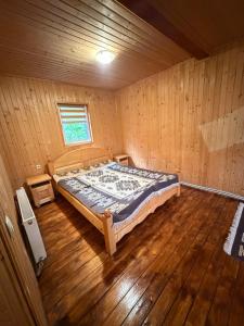 a bedroom with a bed in a wooden room at Садиба у Оксанки in Vorokhta