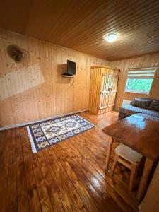 a room with a wooden floor and a table and a tv at Садиба у Оксанки in Vorokhta