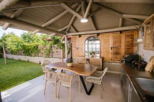 an outdoor kitchen with a wooden table and chairs at Maresol Villa in Nea Kallikrateia