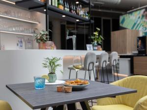 a table with a bowl of food and a glass of wine at ibis Styles Delft City Centre in Delft +55 photos