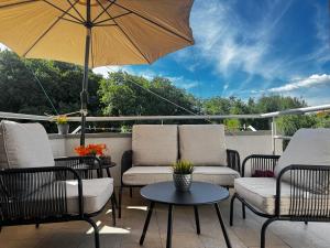 a patio with chairs and a table and an umbrella at Sunset Hill Apartments in Brodarica