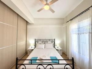 a bedroom with a bed and a ceiling fan at Villa Fenia in Aegiali +100 photos