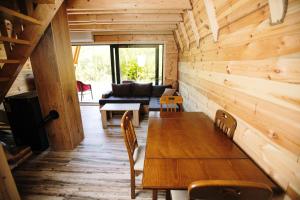 a wooden dining room with a table and a couch at Ujcevina Apartments in Donje Morakovo