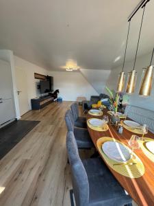 a living room with a long wooden table and chairs at Neubau, Luxus, 3-Zi Wohn für KaffeeGenießer in Eggenstein