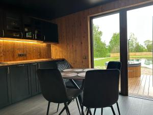 a kitchen with a table and chairs and a patio at Sodyba Anykščių raj. in Anykščiai