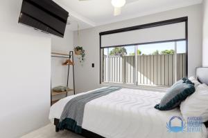 a bedroom with a bed and a large window at Mandurah Poolside Retreat in Coodanup +29 photos