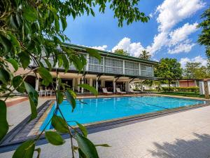 a swimming pool in front of a building at Sorabora Gedara Hotel in Mahiyangana