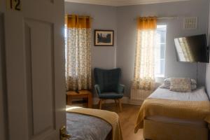 a bedroom with a bed and a chair and a window at Kerrigan's B&B in Mullingar
