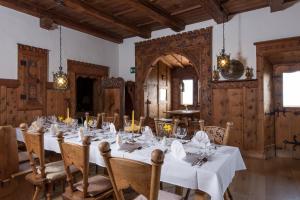 a dining room with a long table with white tablecloths at Hotel Ansitz Kematen ***S in Collalbo