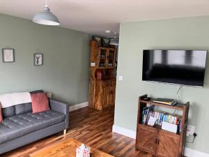 a living room with a couch and a flat screen tv at Silver Birch House in Laune Bridge