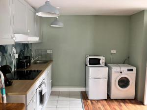 a kitchen with a washing machine and a microwave at Silver Birch House in Laune Bridge