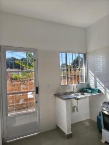 a white kitchen with a sink and a window at Apartamento Próximo ao UNASP in Engenheiro Coelho