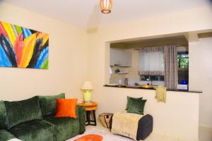 a living room with a green couch and a chair at Savannah suites Bel-Air in Gilgil
