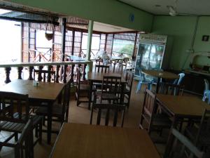 a restaurant with wooden tables and chairs and windows at SPC or SP Barakah at ABC Air Batang Village in Tioman Island