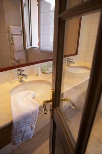 a bathroom with two sinks and a mirror at Hôtel des Pyrénées in Saint-Jean-Pied-de-Port