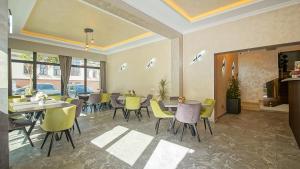 a dining room with tables and yellow chairs at Sub Cetate in Râşnov +44 photos