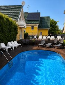 a large blue swimming pool in front of a house at Pool Hause Palanga in Palanga