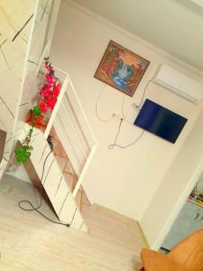 a room with a staircase and a shelf with flowers at Green House in Kobuleti