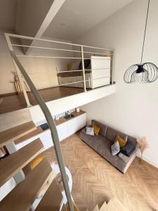 a living room with a staircase and a couch at Loftas Smilga in Palanga