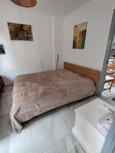 a bed in a white room with posters on the wall at Reka Casa in Mojácar