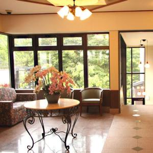 a living room with a table with flowers on it at Gora Hotel Paipuno Kemuri Plus in Hakone