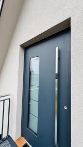 a blue door of a building with a window at Klimatisierte Komfort-Eifel-Ferienwohnung Mechernich, Obergartzem, Satzvey - nahe Krewelshof, Burg Satzvey & Phantasialand in Mechernich