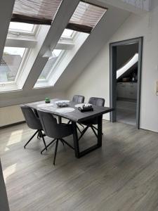 a table and chairs in a room with skylights at Ferienwohnung am Flughafen in Braunschweig
