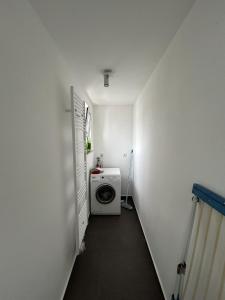 a hallway with a washing machine in a white room at Monteur-Ferienwohnung Julianna in Bad Staffelstein in Bad Staffelstein