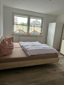 a bed in a bedroom with two windows at Monteur-Ferienwohnung Julianna in Bad Staffelstein in Bad Staffelstein