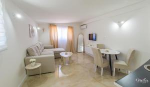 a living room with a couch and a table and chairs at Apartments Elle in Čitluk