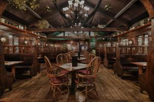 a restaurant with wooden tables and chairs and a chandelier at Lamies Inn & The Old Salt Tavern in Hampton