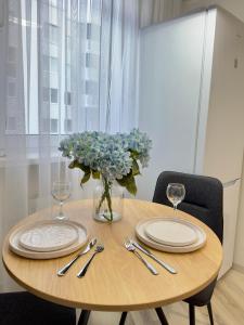 a wooden table with plates and a vase of flowers at Home sweet home 2 in Chişinău +4 photos