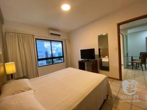 a bedroom with a large white bed and a window at Flat no Condomínio Metrópolis - Ilha do Leite in Recife