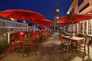 a row of tables and chairs with red umbrellas at Lamies Inn & The Old Salt Tavern in Hampton