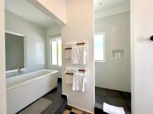 a white bathroom with a tub and towels at Verdaad Mansion in La Libertad +34 photos