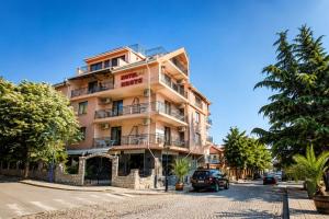 a building with a car parked in front of it at Family Hotel Kosko in Chernomorets