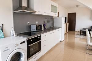 a kitchen with a washer and a stove top oven at Family Hotel Kosko in Chernomorets