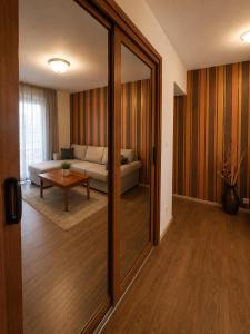 a living room with a couch and a mirror at Family Hotel Kosko in Chernomorets