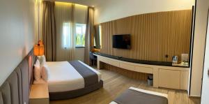 ein Hotelzimmer mit Bett und Fernseher in der Unterkunft Tanger Miramonte - Resort Seaside Suites & Double Rooms in Tangier