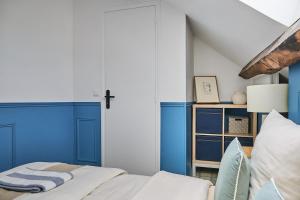 a bedroom with blue and white walls and a bed at Appartement Houdan centre-ville in Houdan +14 photos