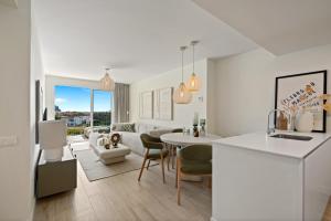 a white kitchen and living room with a table and chairs at Casa Costa Xàbia in Jávea