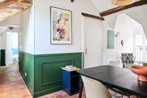 a dining room with a green table and chairs at Appartement Houdan centre-ville in Houdan