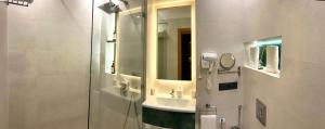 ein Badezimmer mit Dusche, Waschbecken und Spiegel in der Unterkunft Tanger Miramonte - Resort Seaside Suites & Double Rooms in Tangier