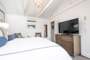 a bedroom with a bed and a flat screen tv at Boothbay Harbor Oceanside Inn in Boothbay Harbor